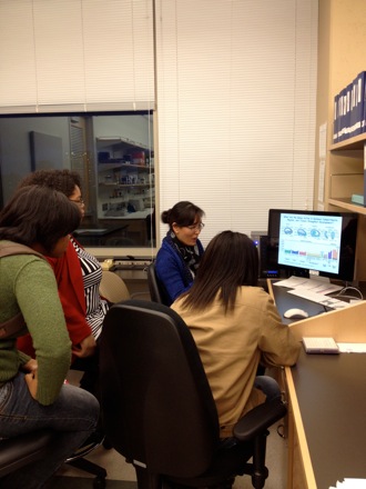 Lab member Jungim shows Tuskegee students the lab's research on soybeans.
