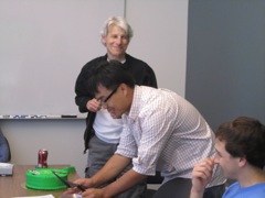 Brandon cuts the cake for the students and lab members.
